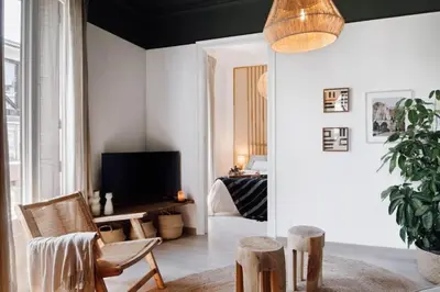 a bedroom with a white couch and some plants at Bari - 2 bedroom and office in Sant Antoni in Barcelona