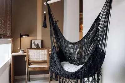 a black hammock in a room with a chair at Zioba - 3 bedroom and balcony in Gracia in Barcelona