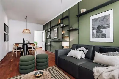 a living room with a black couch and green walls at Kamina - 2 bedroom in Passeig de Gracia in Barcelona