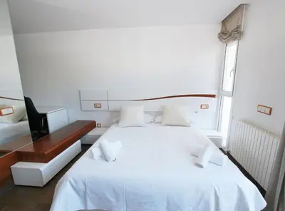 a bedroom with a white bed and a desk at Rey apartment in Vilassar de Mar