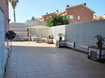 a patio with a fence and a table and chairs at Rey apartment in Vilassar de Mar