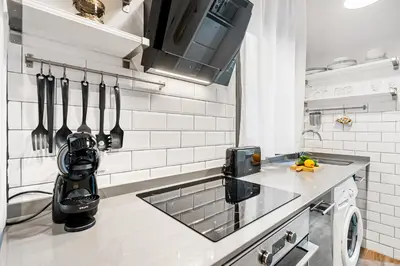 a kitchen with a counter with utensils on the wall at Lodging Apartments Almirall Beach 11 in Barcelona