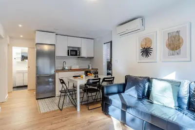 a living room with a blue couch and a kitchen at 2124 - AB Poblenou Beach Comfort in Barcelona