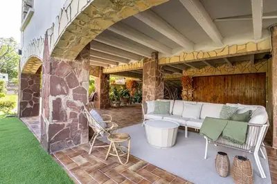 a patio with a couch and a table and chairs at Vista Serena in Sant Cugat del Vallès