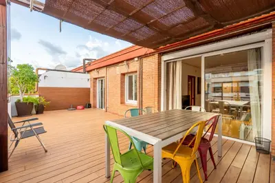 a deck with a wooden table and chairs at Precioso Atico Vistas Montjuic in Barcelona