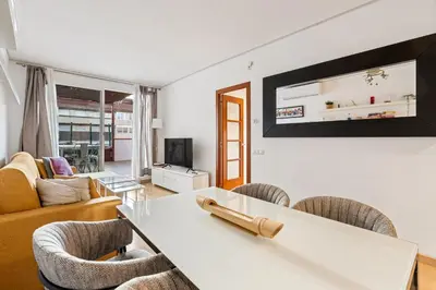 a living room with a white table and chairs at Precioso Atico Vistas Montjuic in Barcelona