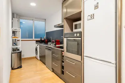 a kitchen with stainless steel appliances and a refrigerator at Precioso Atico Vistas Montjuic in Barcelona