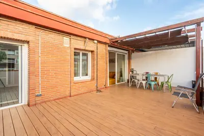 a large deck with a table and chairs on it at Precioso Atico Vistas Montjuic in Barcelona