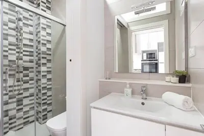 a white bathroom with a sink and a mirror at Cozy And Quiet In Trendy Sants in Barcelona
