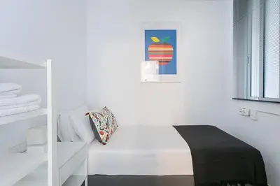 a white room with a bed and a picture of an apple at Relax In A Chic Apartment In Sants in Barcelona