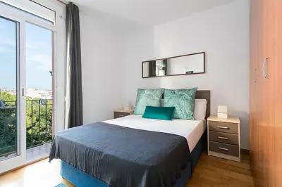 a bedroom with a bed and a large window at Relax In A Chic Apartment In Sants in Barcelona