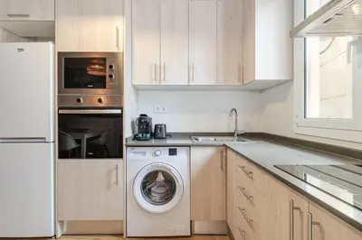a kitchen with a washing machine and a washer at Live Like A Local In Eixample in Barcelona