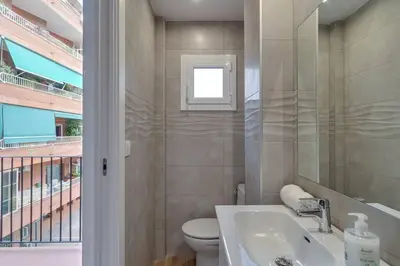 a bathroom with a sink and a toilet and a window at Live Like A Local In Eixample in Barcelona