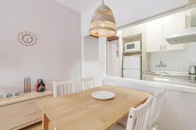 a dining room with a wooden table and a kitchen at Stylish Apartment In Gracia in Barcelona