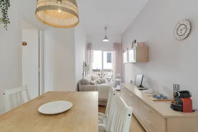 a kitchen with a table and a living room at Stylish Apartment In Gracia in Barcelona