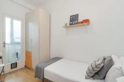 a white bedroom with a bed and a window at Stylish Apartment In Gracia in Barcelona