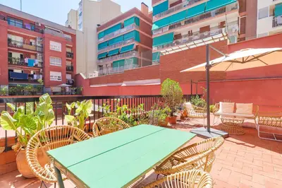 a green table and chairs on a patio with buildings at Amazing Terrace In Sant Andreu in Barcelona