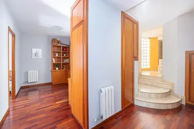 a hallway with wooden floors and a staircase in a house at Bright Attic & Amazing Terrace in Hospitalet de Llobregat