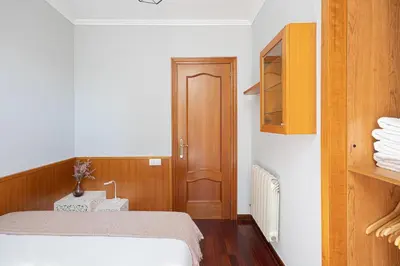 a bedroom with a bed and a wooden cabinet at Bright Attic & Amazing Terrace in Hospitalet de Llobregat
