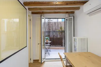 a dining room with a table and a sliding glass door at Cozy Studio In Ciutat Vella in Barcelona