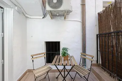 a table and chairs on a balcony with a fan at Cozy Studio In Ciutat Vella in Barcelona