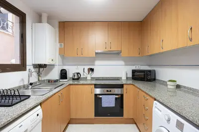 a kitchen with wooden cabinets and a stove top oven at Lovely&cozy In Born in Barcelona
