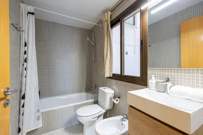 a bathroom with a toilet and a sink and a tub at Lovely&cozy In Born in Barcelona