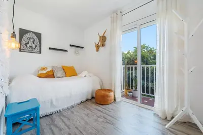 a bedroom with a bed and a large window at Hauzify I Apartament Zulú Cubelles in Cubelles