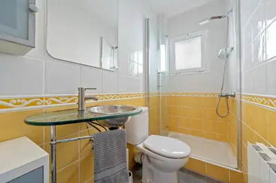 a bathroom with a toilet and a sink and a shower at Hauzify I Apartament Zulú Cubelles in Cubelles