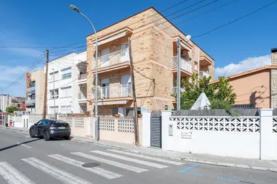 a car parked in front of a brick building at Hauzify I Apartament Zulú Cubelles in Cubelles