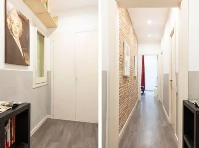 a hallway with white walls and a brick wall at Canela Homes BARCELONA URQUINAONA in Barcelona
