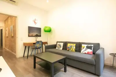 a living room with a couch and a table at Canela Homes BARCELONA URQUINAONA in Barcelona