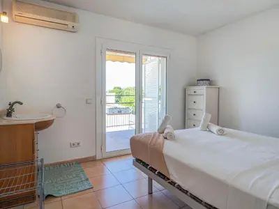 a bedroom with a bed and a door to a balcony at Arlene apartment by Hello Homes Sitges in Sitges