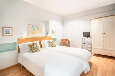 a bedroom with a large white bed and a tv at EL BORN - Barcelona - Port 5 pax 2 bedrooms in Barcelona