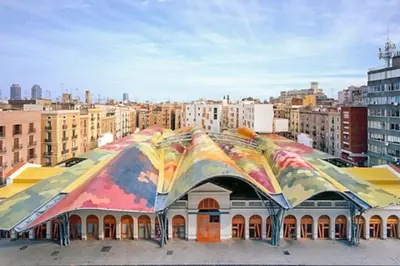 a large building with a colorful roof in a city at EL BORN - Barcelona - Port 5 pax 2 bedrooms in Barcelona