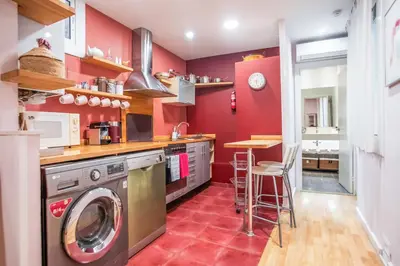 a kitchen with red walls and a washer and dryer at EL BORN - Barcelona - Port 5 pax 2 bedrooms in Barcelona