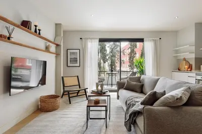 a living room with a couch and a kitchen at Aiguablava - 1 bedroom and pool in Pedralbes in Barcelona