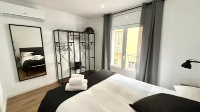 a bedroom with a large white bed and a mirror at CENTRO CON TERRAZA NGRO BY PRESTIGI in Terrassa