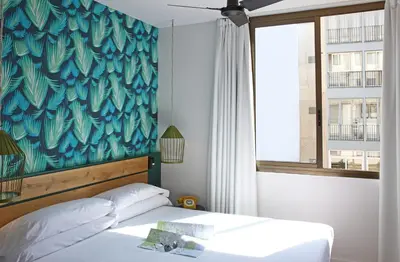 a bedroom with a bed with a blue wall at Chic & Basic Lemon Boutique Hotel in Barcelona