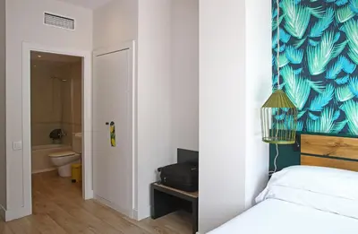 a bedroom with a bed and a blue and white wall at Chic & Basic Lemon Boutique Hotel in Barcelona