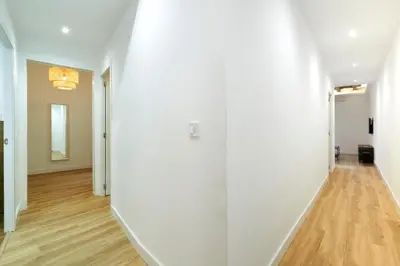 an empty hallway with white walls and wood floors at Comfortable apartment next to Apolo theater in Barcelona