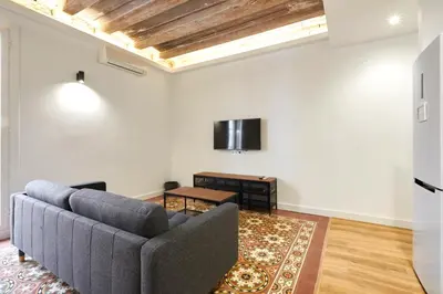 a living room with a couch and a tv at Comfortable apartment next to Apolo theater in Barcelona