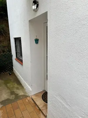 a hallway of a white building with a window and a plant at Vista Alegre Rest House for 7 Persons in Vallromanas