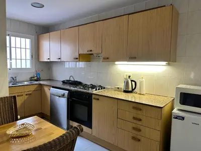 a kitchen with wooden cabinets and a stove top oven at Vista Alegre Rest House for 7 Persons in Vallromanas