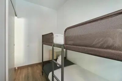 a bunk bed in a small room with a ladder at Ol Cute apartment in quiet Olivera st in Barcelona