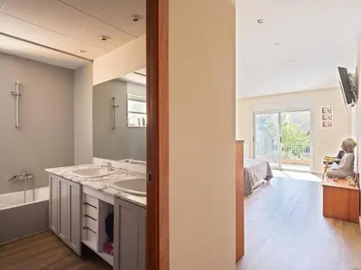 a bathroom with two sinks and a tub and a person at Villa Marítima in Pineda de Mar in Pineda de Mar