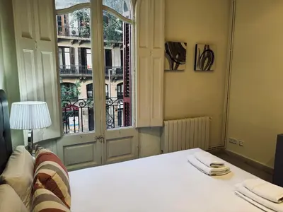 a bedroom with a bed and a large window at Sweet BCN Borrell in Barcelona