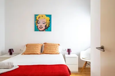 a bedroom with a bed with a red blanket at Centric apartment Gràcia in Barcelona