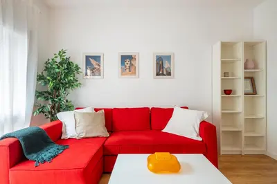a red couch in a living room with a table at Centric apartment Gràcia in Barcelona