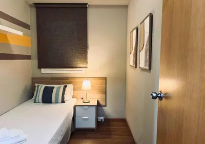 a small bedroom with a bed with a lamp and a window at Sweet BCN Laforja in Barcelona